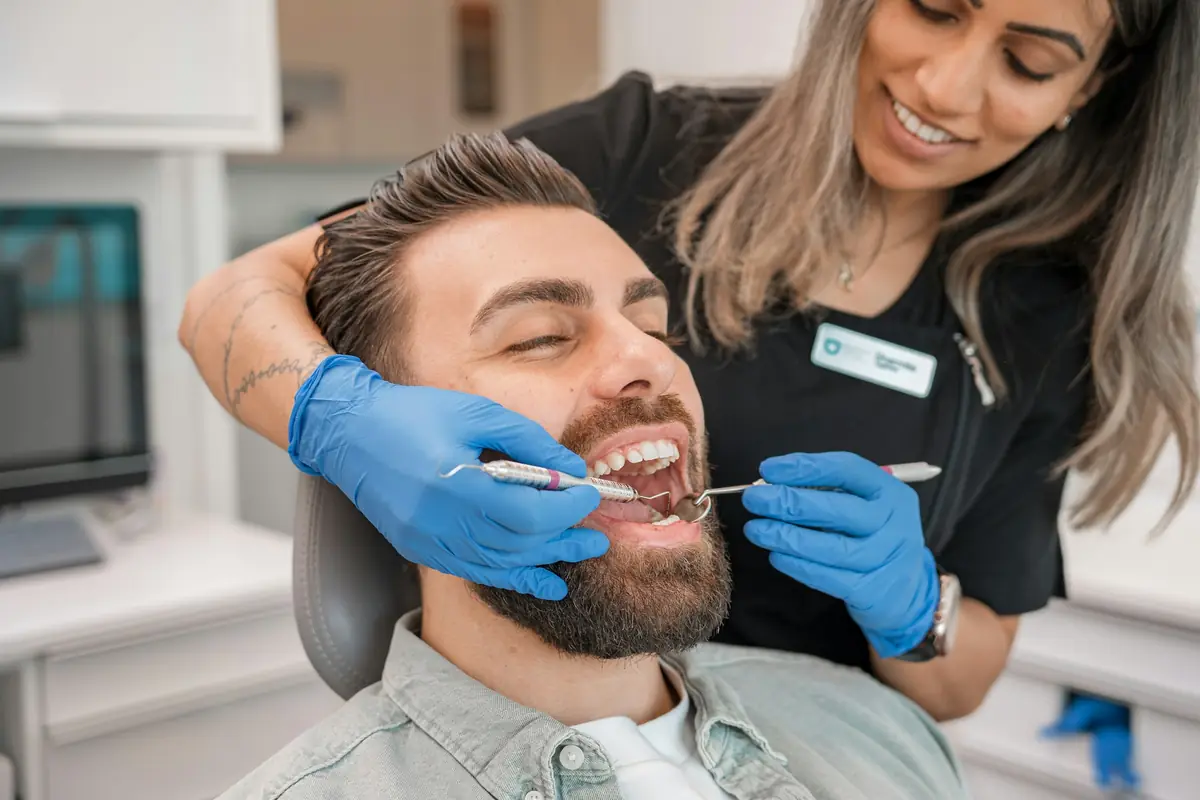A hygienist and a laughing patient during a checkup