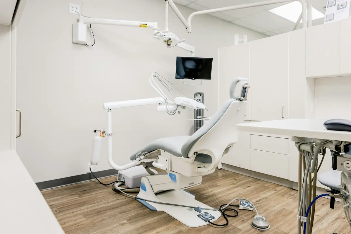 A bright, tidy treatment room with a modern dental chair